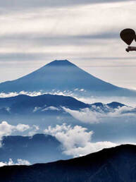Berggipfel, Trouble Travel Bus fliegt mit 2 Luftballons in der Luft
