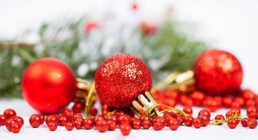 rote weihnachtskugeln, liegend umgeben von weihnachtsdekoration